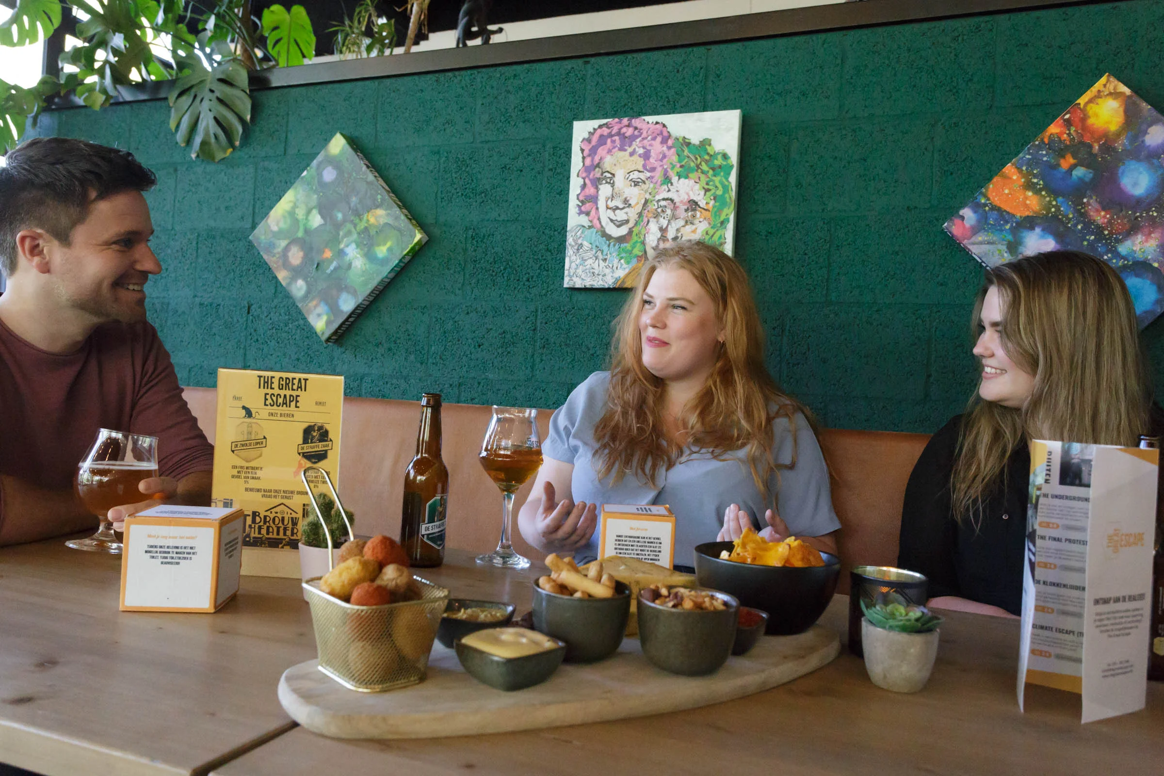 Cheerful friends laughing and drinking in the cozy escape café.
