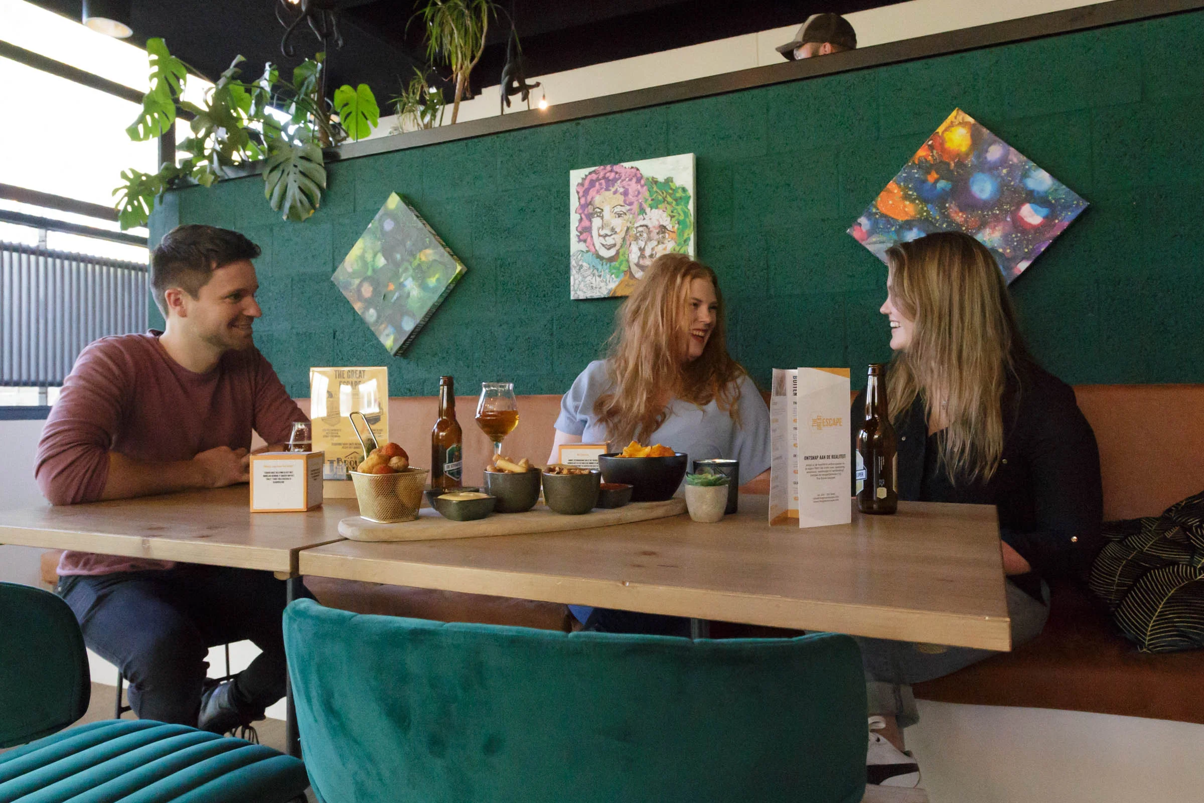 Friends relaxing in the escape café, laughing and drinking beer.