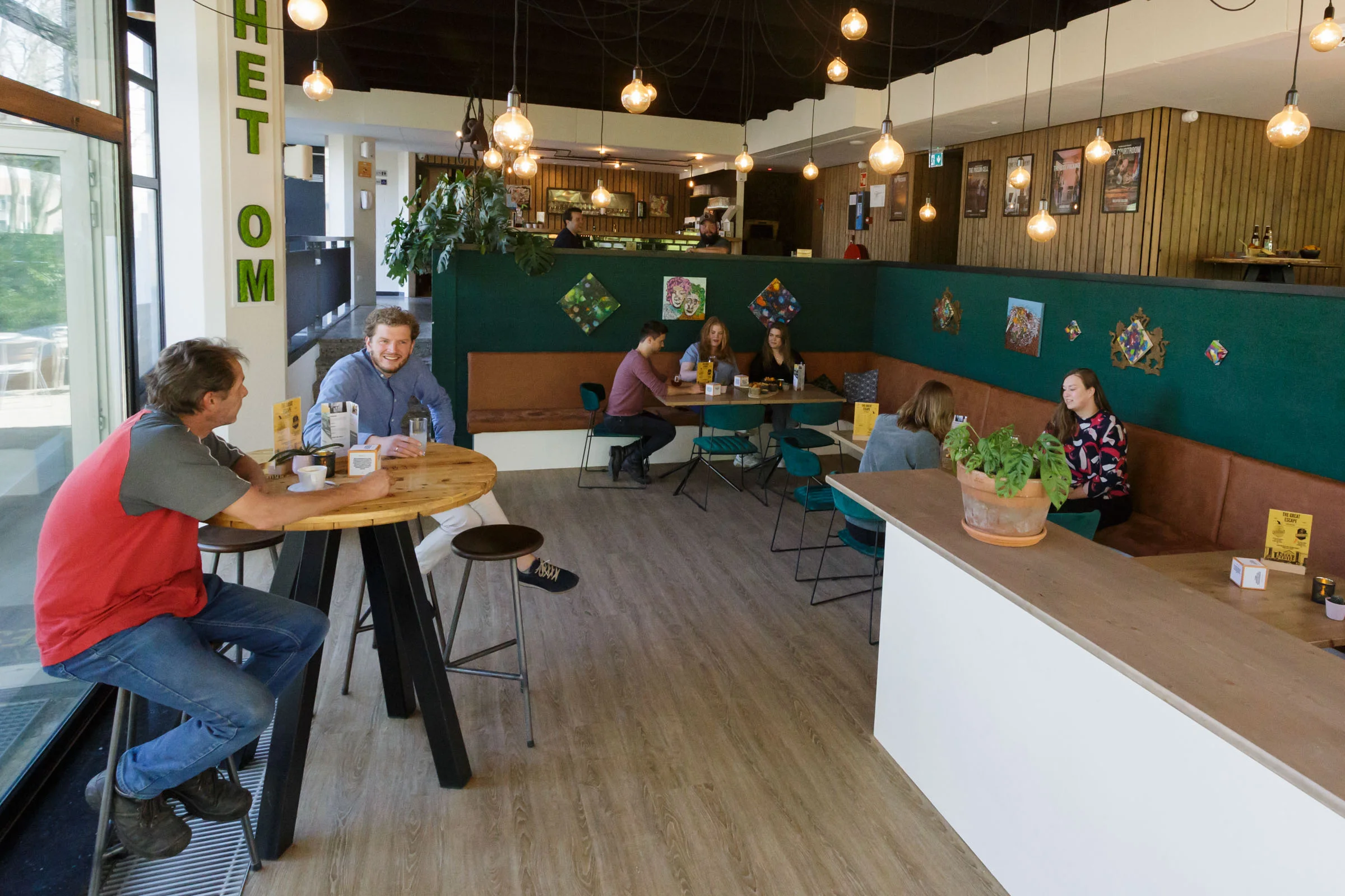Cozy atmosphere in the escape café with laughing people at tables.