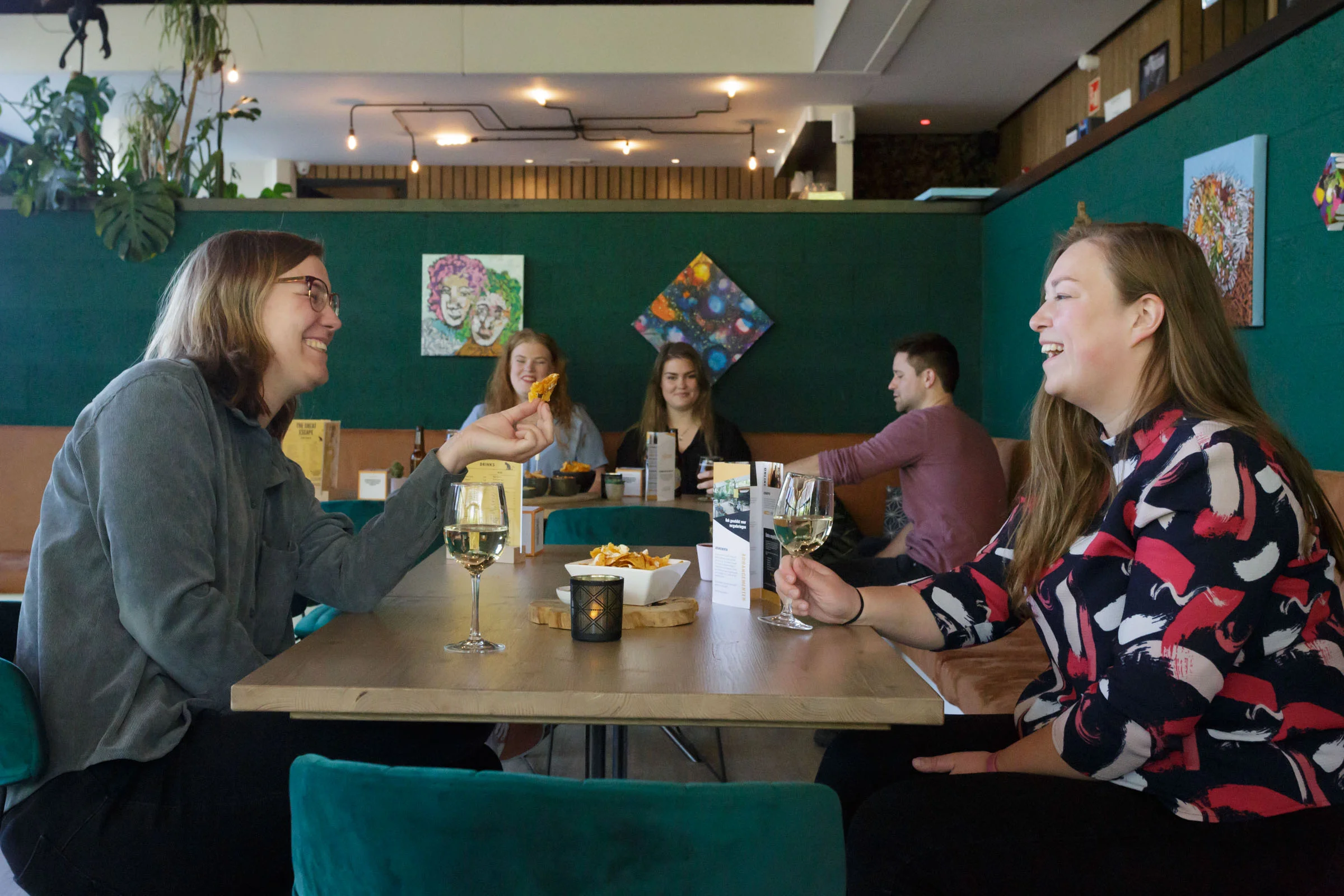 Cheerful people having drinks in a relaxed atmosphere, enjoying beverages and snacks.