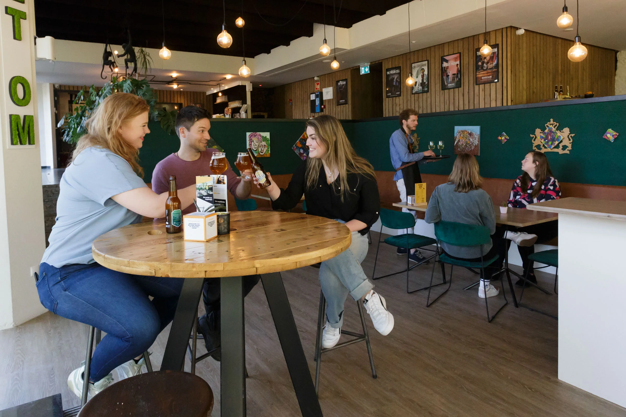 Cheerful people toasting with beer in an atmospheric escape café.
