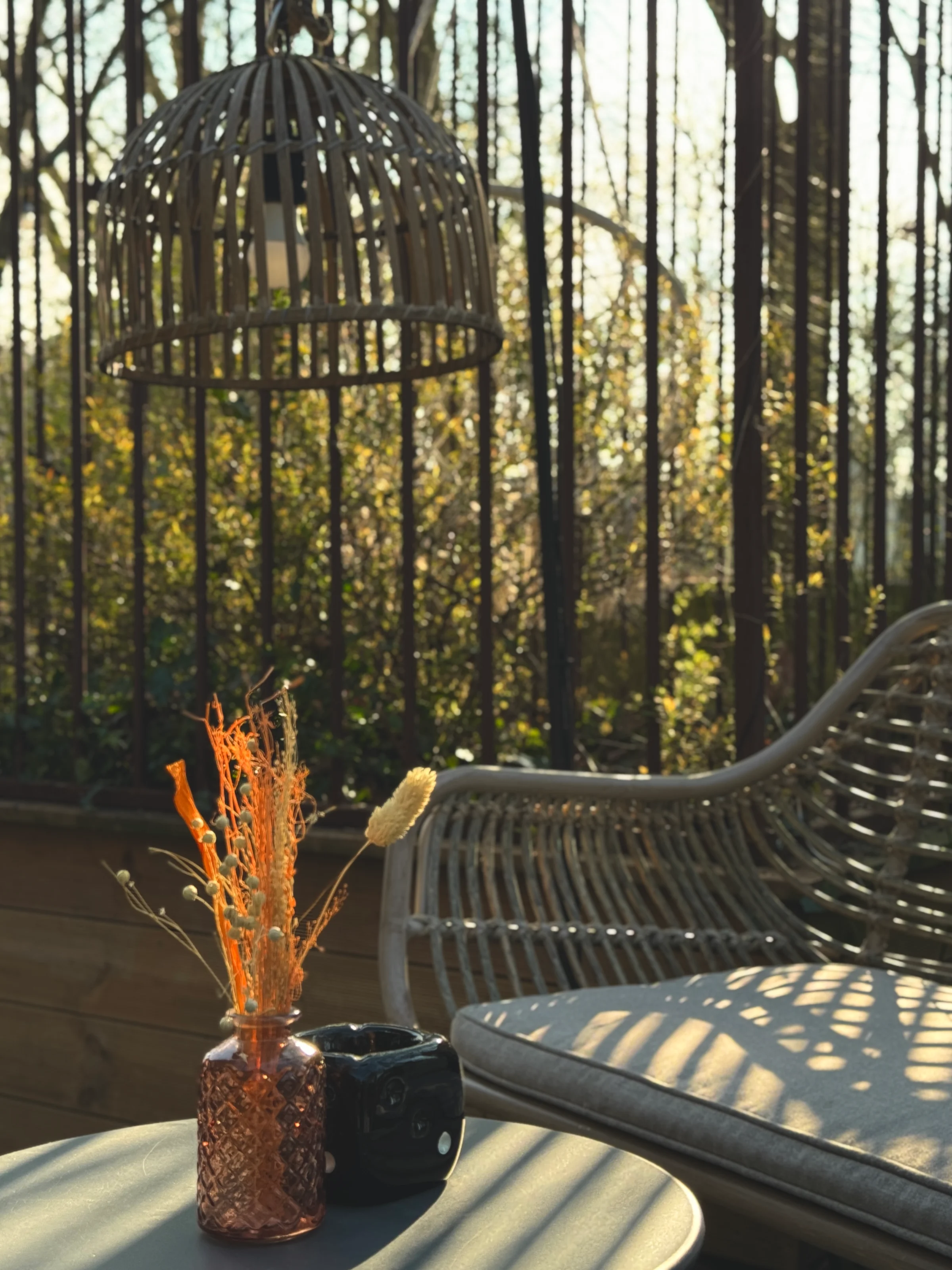 Atmospheric terrace with bamboo lamp, dried flower vase, and lounge sofa.